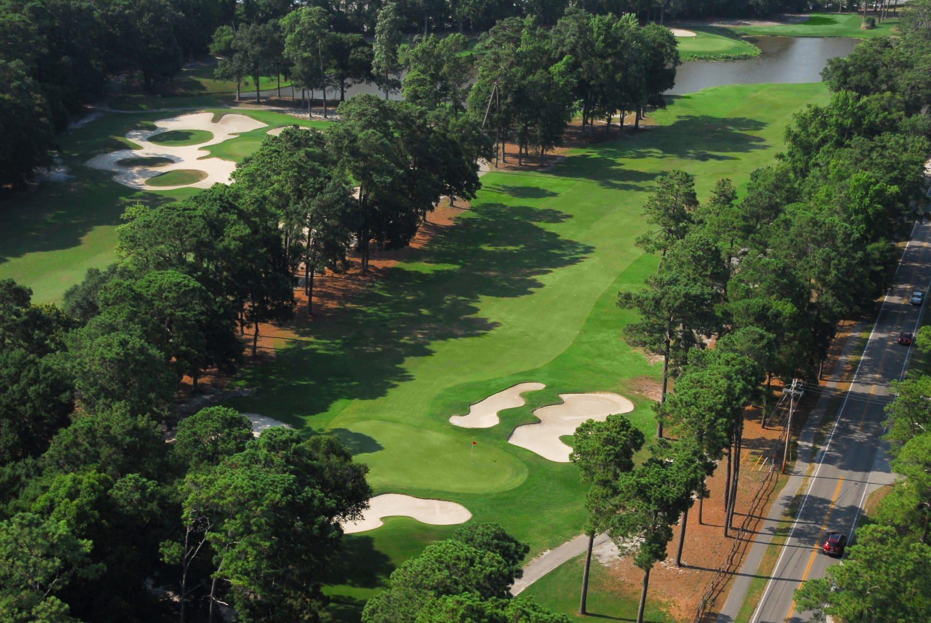 Aerial view of a wide fairway littered with sand bunkers