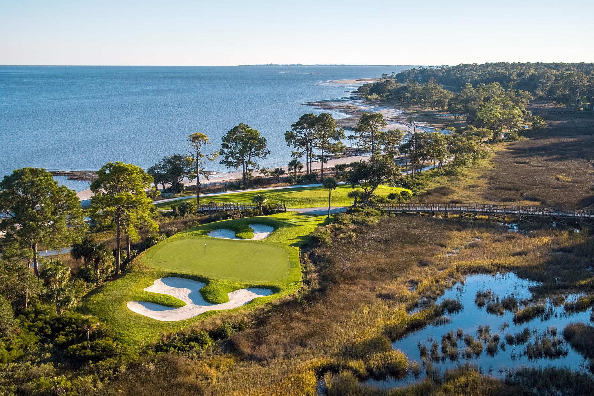 A green lies near the coastline with ocean views.