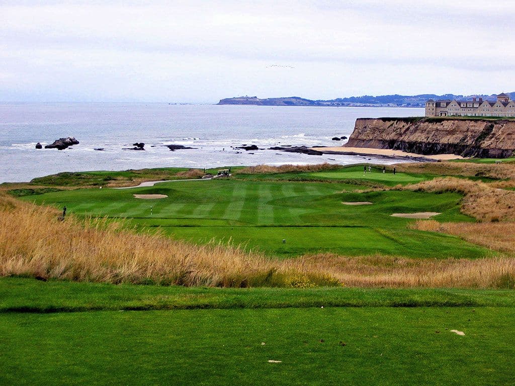 A Coastal green surrounded by sand bunkers with a mature rough