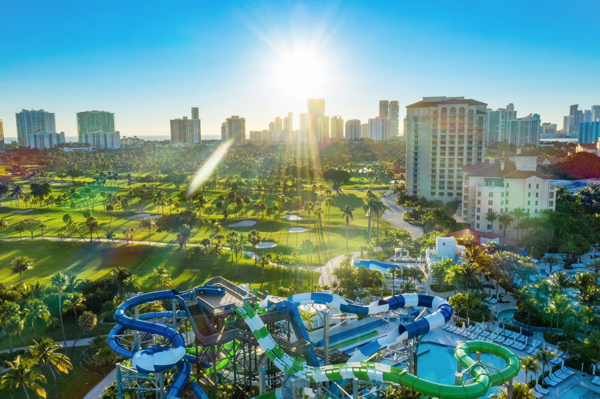 Sun shining over the swimming pool at JW Marriott Turnberry Resort & Spa equipped with water slides