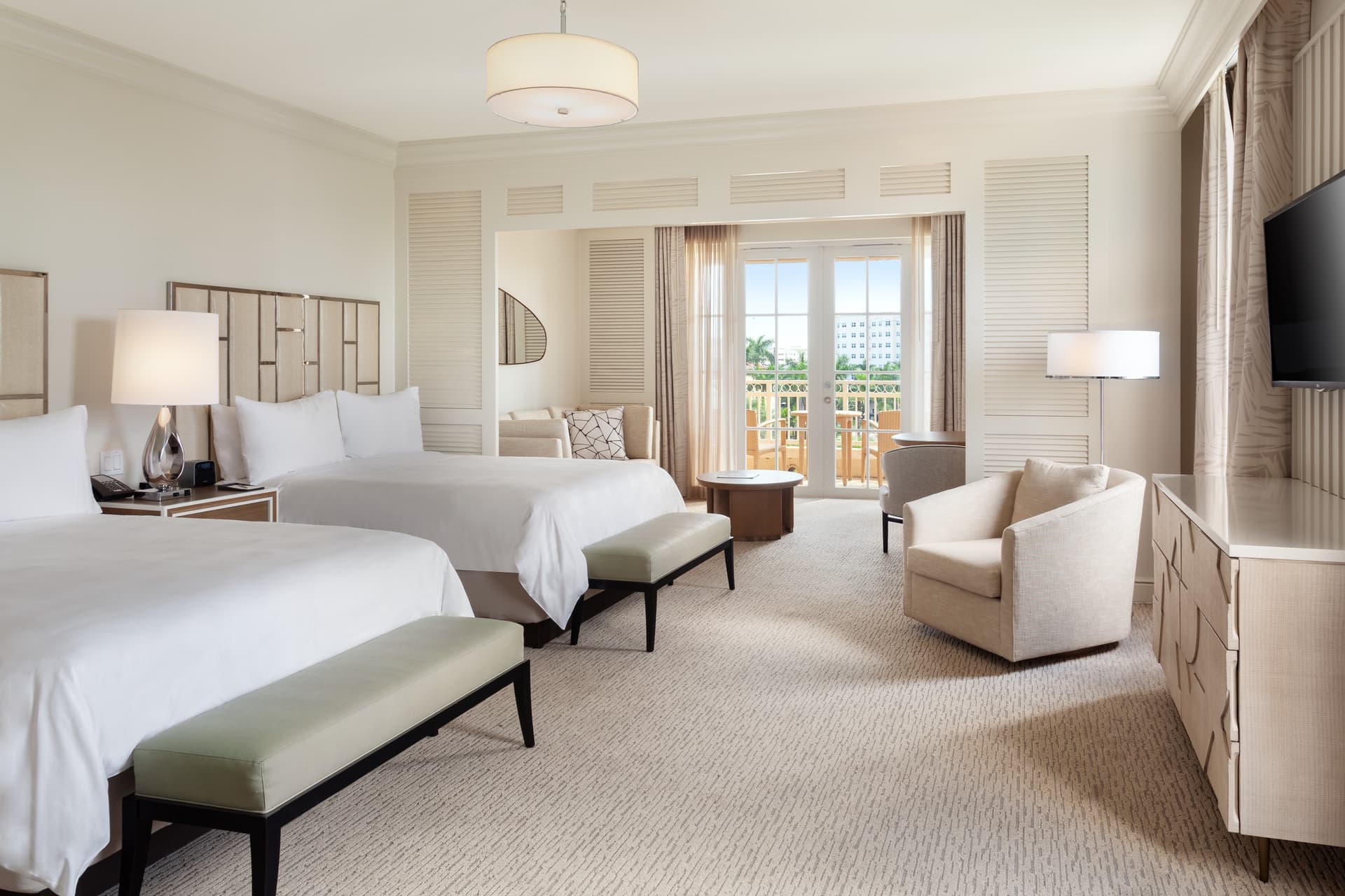 Modern double bed suite at the resort following a creme design with balcony views