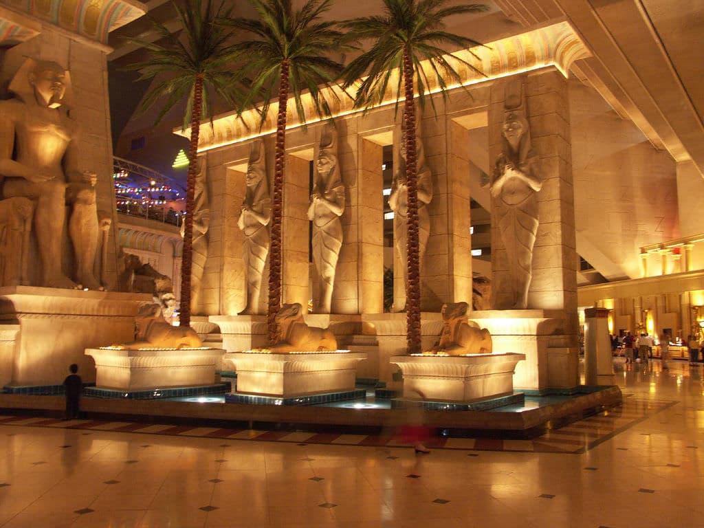 Palm trees surrounding the building being lit up by the resorts lioghts