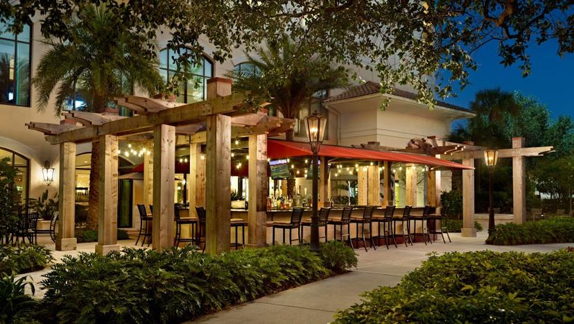 Outside bar at the Onmi Orlando Resort with seating, umbrella and TV for entertainment