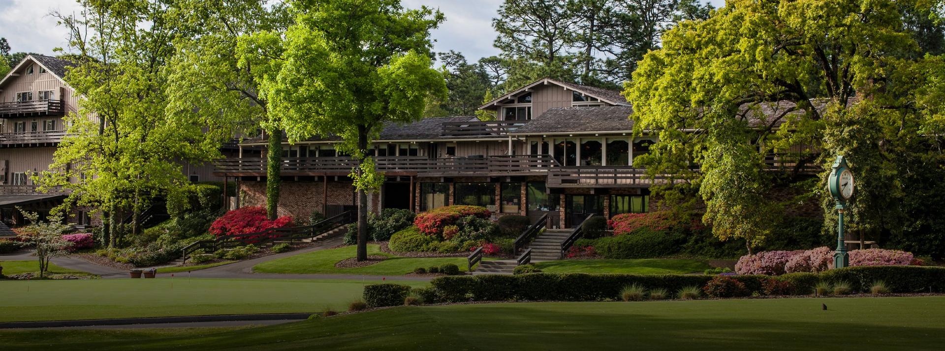 The Pine Needles clubhouse surrounded by vibrant flowers and nature looking over the course