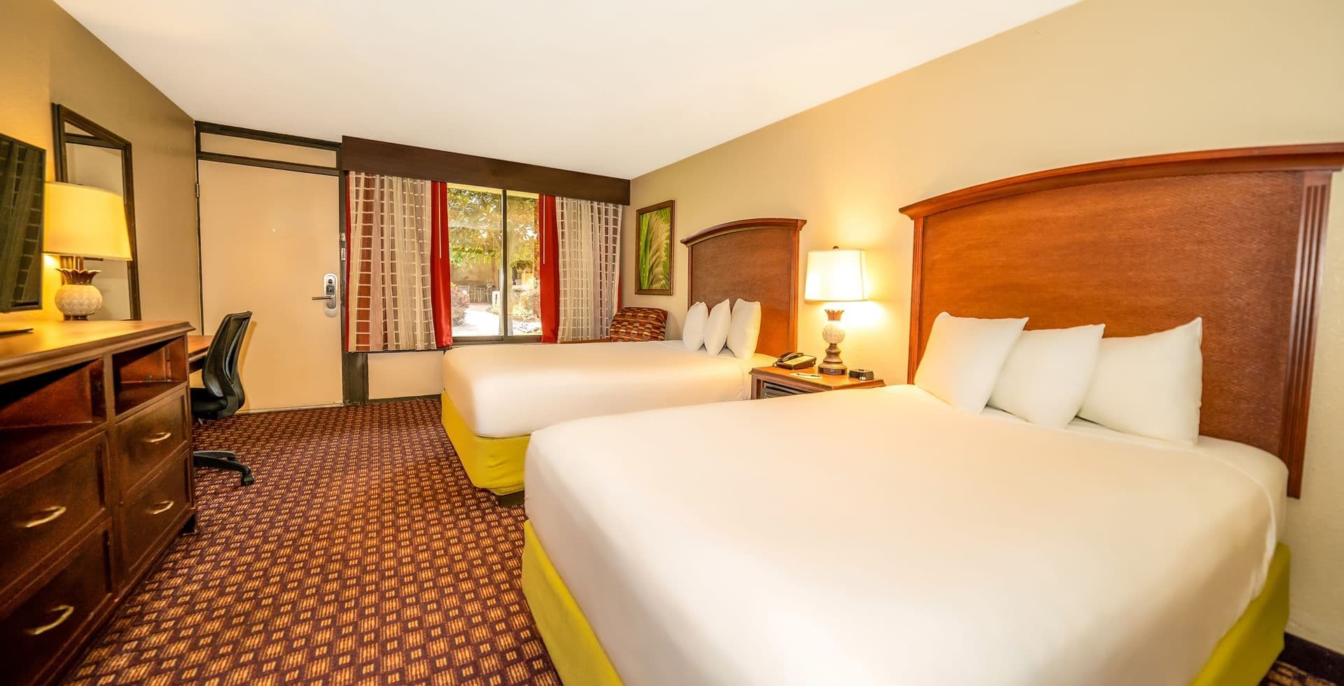 Twin double bed room at the hotel with a TV and window looking out to the walk path and nature