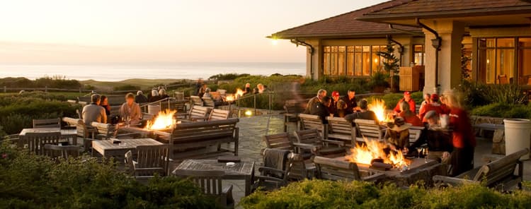 Outdoor seating area at The Inn with multiple fire pits for guests to enjoy and views of the course and sea
