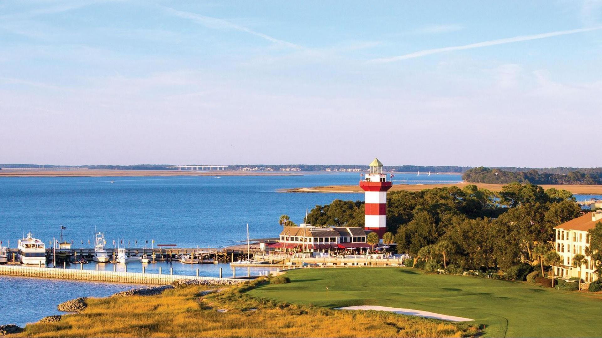 A lighthouse stands by the marina next to the edge of the golf course.