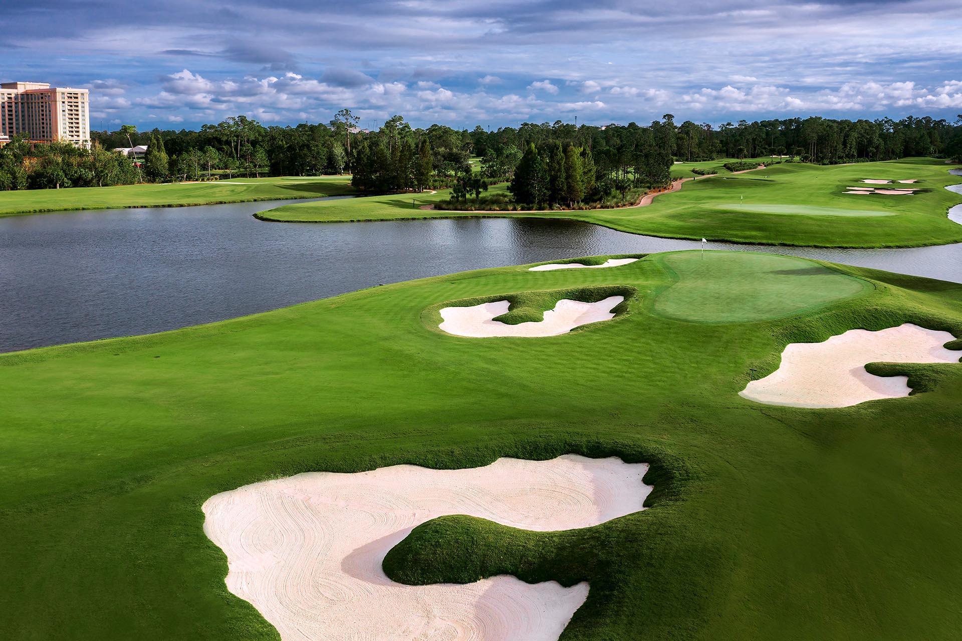 A beautiful lakeside golf hole with pristine white sand bunkers and manicured fairways.