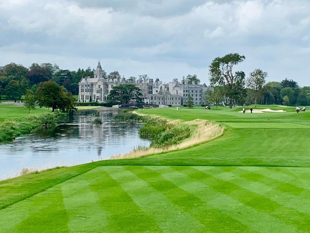 The fairway stretching towards the castle with the river on the left and golfers in the distance.