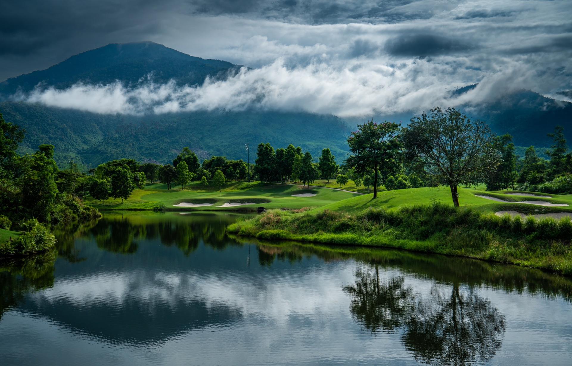 Ba Na Hills Golf Club, with a large water hazard in front of a green, mountains in the background