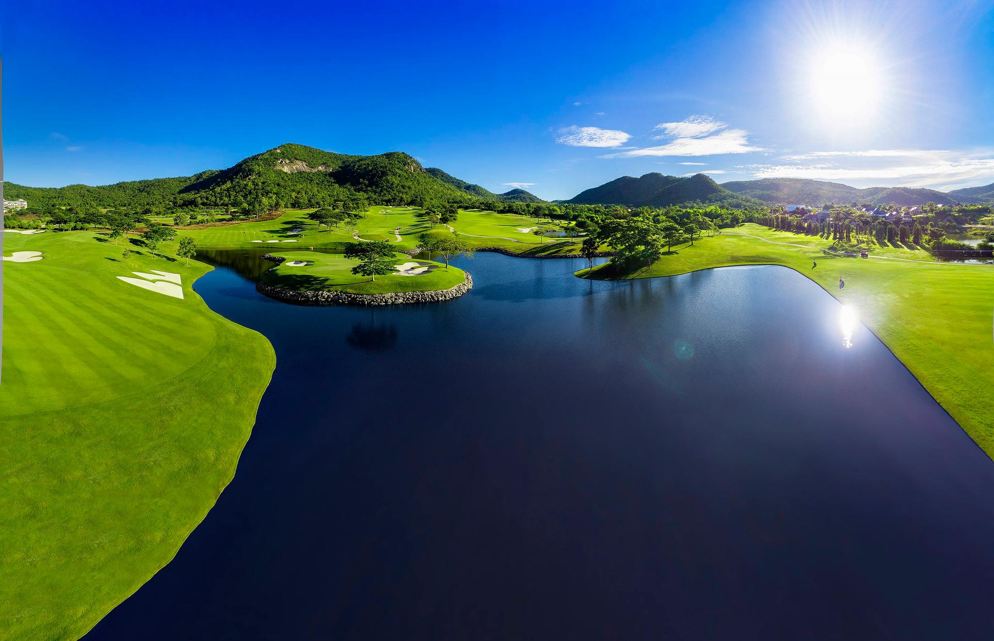 The sun shining over the Black Mountain Golf Course and reflecting off the water hazard