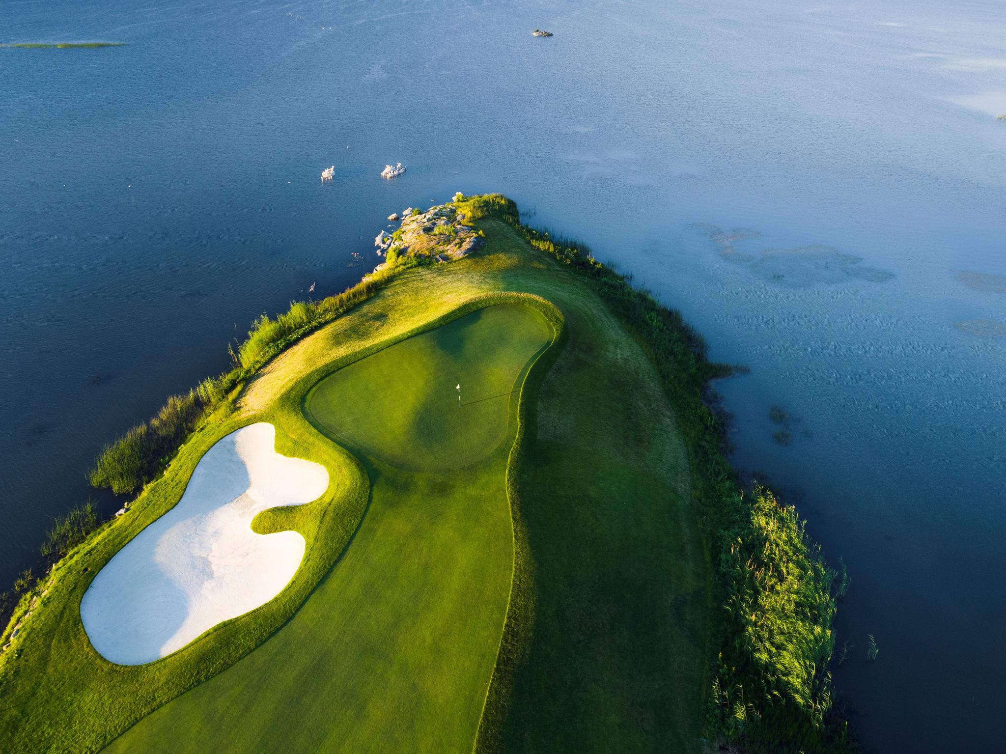 Birdseye view of an island green at The Stadium Course with a sand bunker next to the green