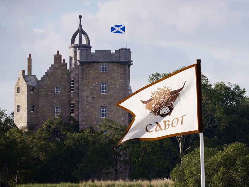 The Cabot Highlands logo flagstick being overlooked by the hotel