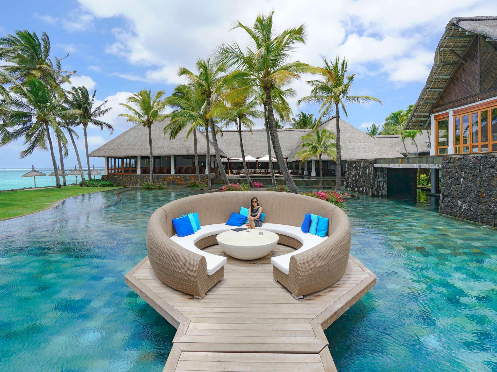 An island seating area at the resort surrounded by water with a wooden bridge to navigate the resort