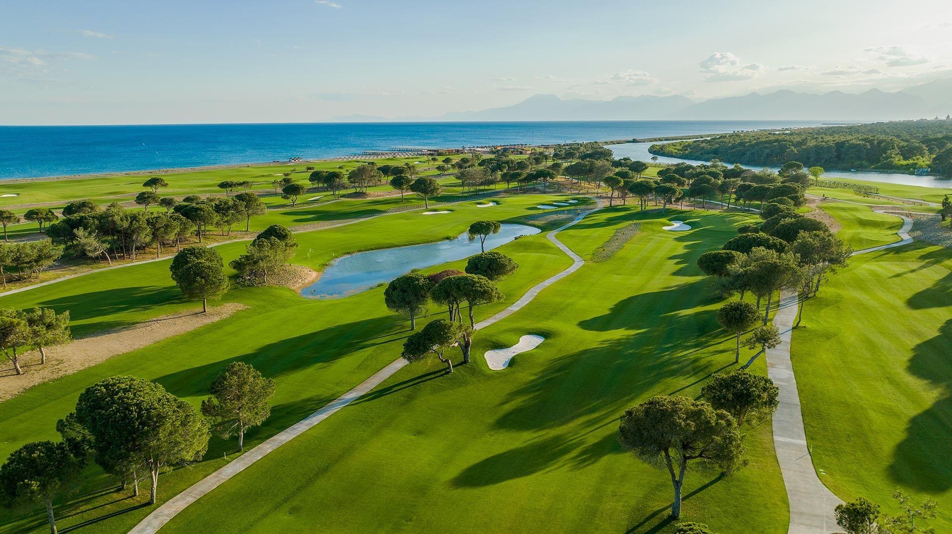 Aerial view of the golf course with manicured fairways and the ocean in the background