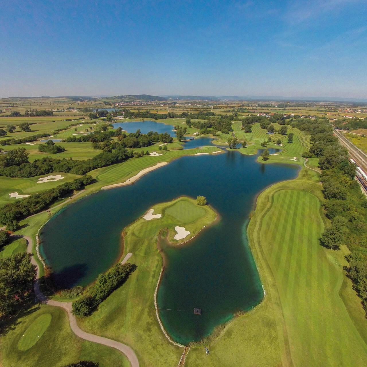Birdseye view of an island green surrounded by a large water hazard at the Diamond Country Club