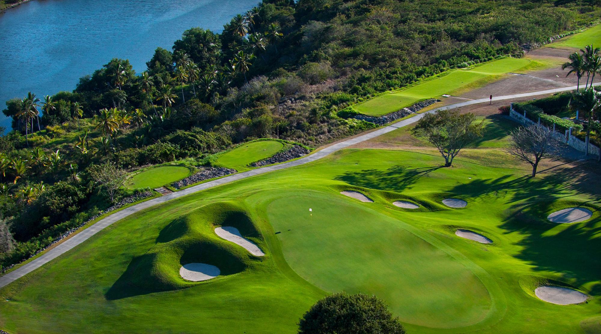 A well-kept green littered with surrounding sand bunkers