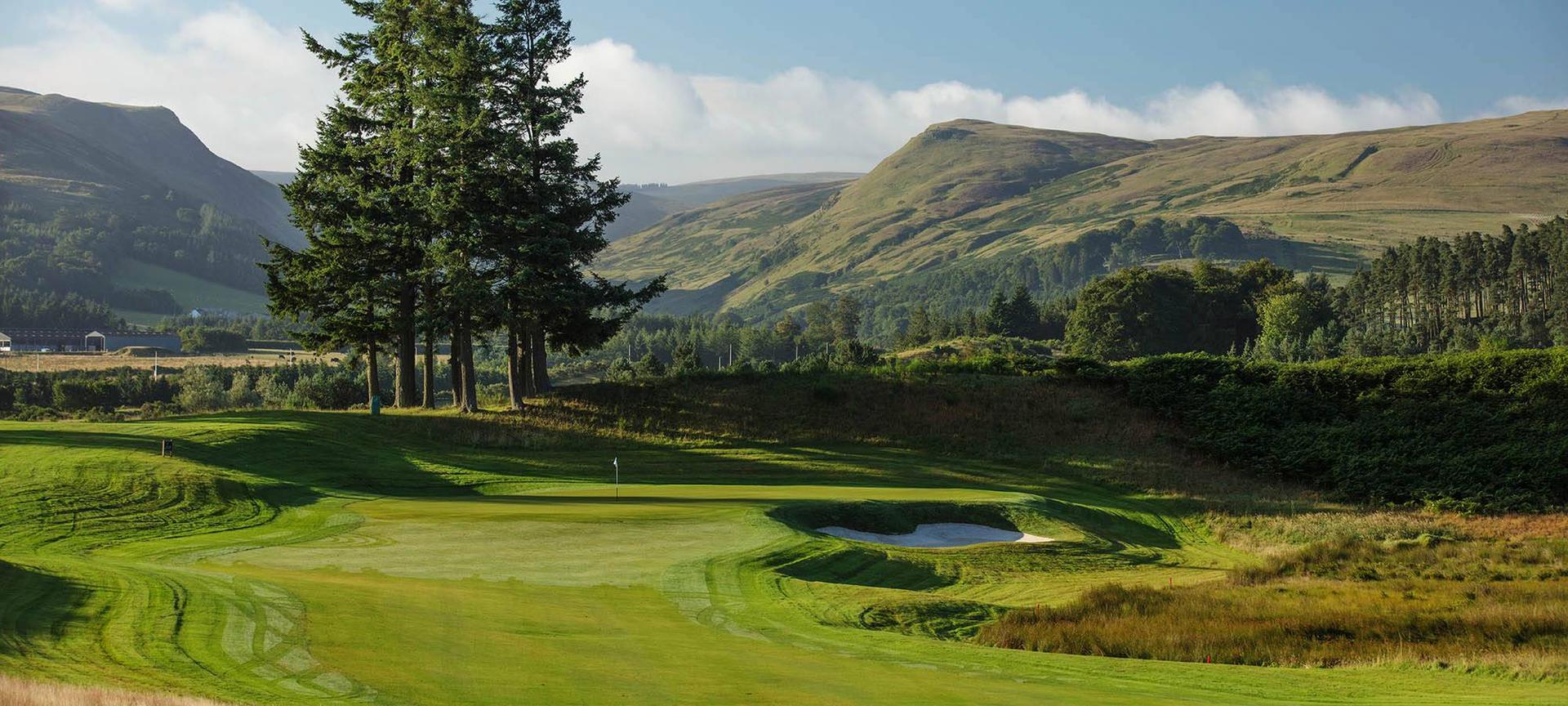Wide view of the well maintained green with mountain views in the distance