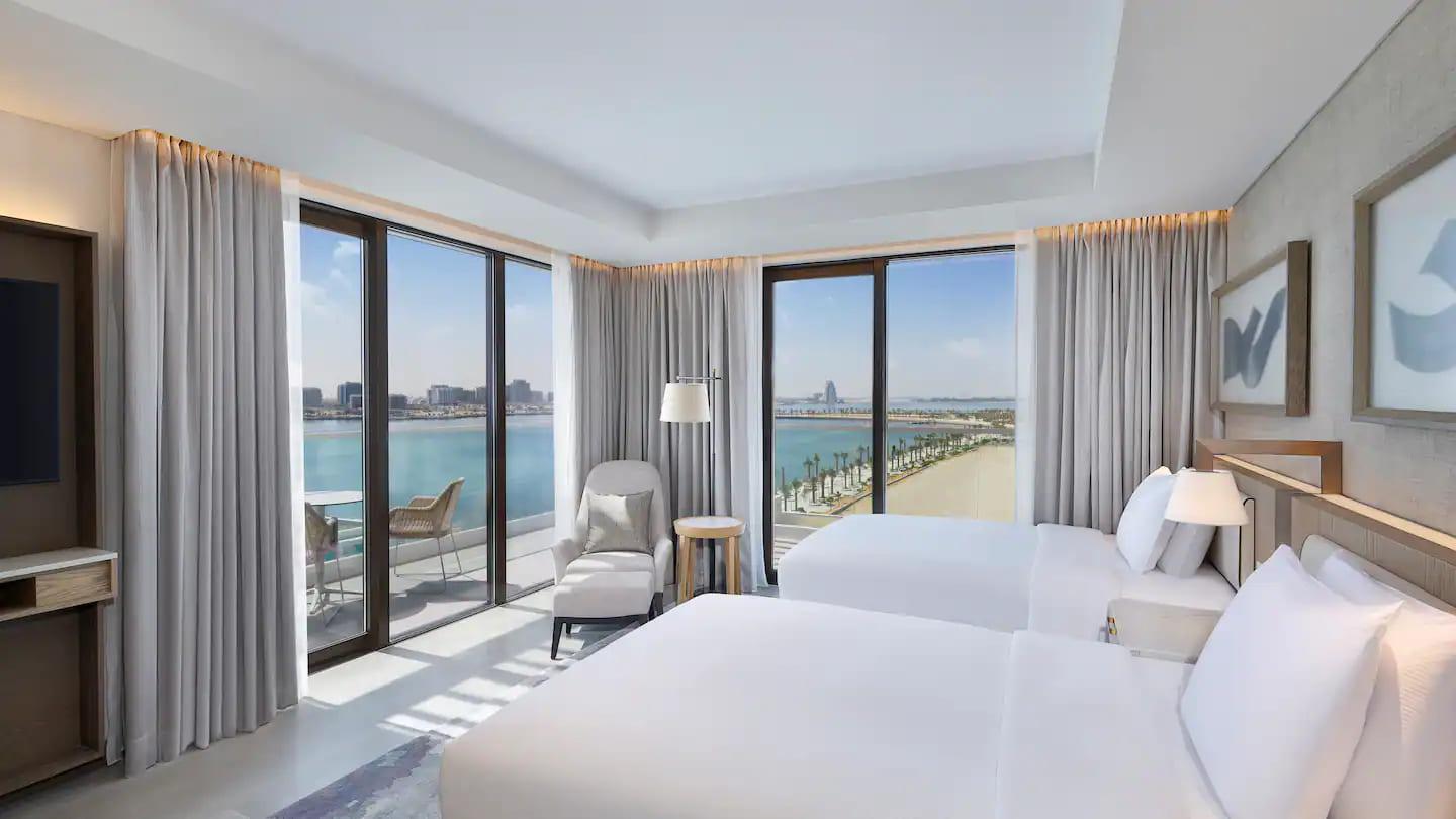 Twin double bed suite at the hotel with balcony views of the beach