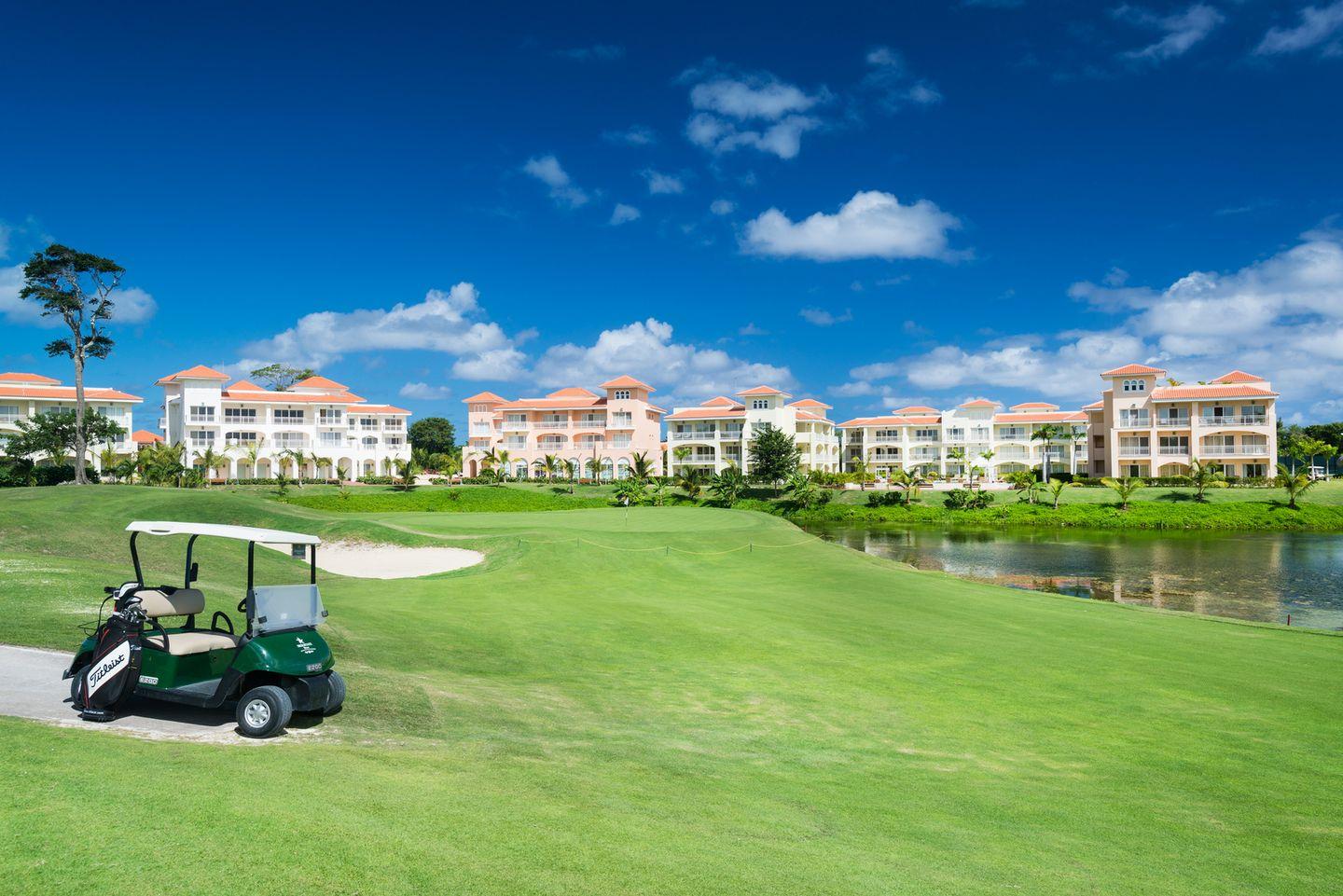 Buggies parked next to a smooth green on the course