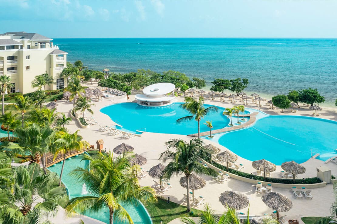 Large outdoor swimming pool with surrounding sun beds and easy access to the beach
