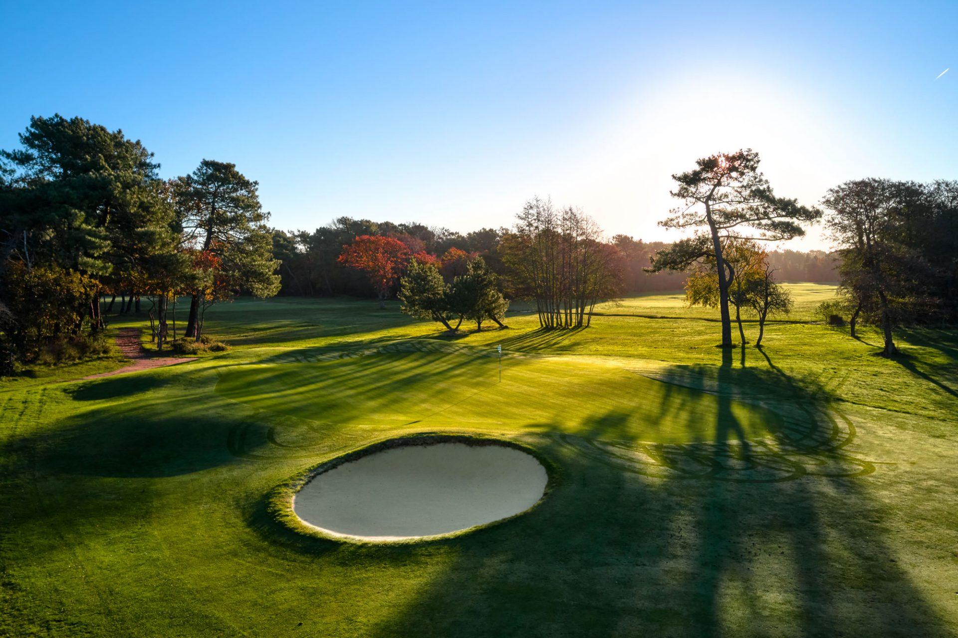 Green on a golf course with a bunker in front
