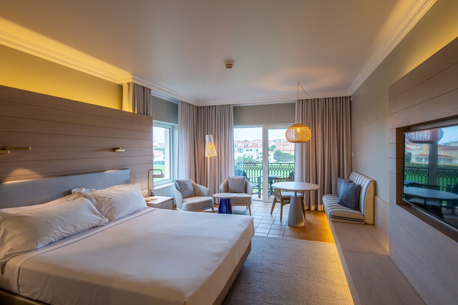 Double bed with living area, television and balcony