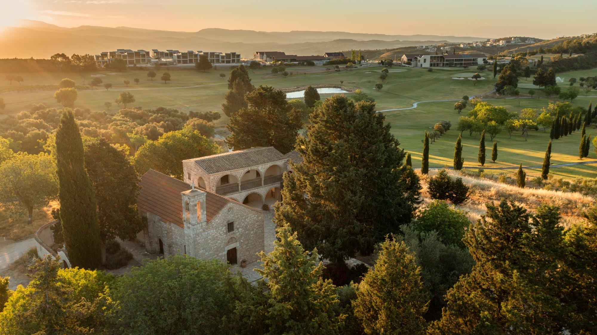 Overhead view of the sun setting over the Minthis Resort's golf course with villas in the background