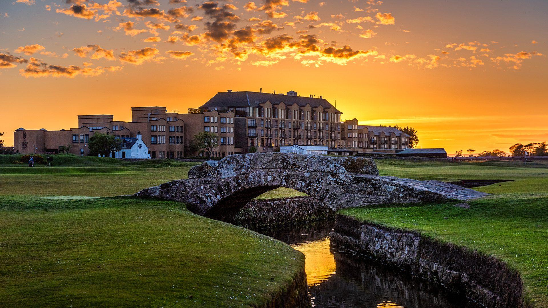 The Old Course Hotel glows at sunset, standing majestically beside the iconic Swilcan Bridge.