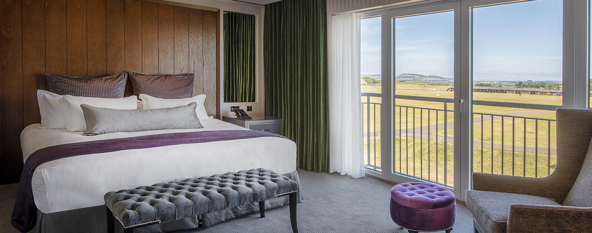 Modern purple themed bedroom with balcony views of the coourse