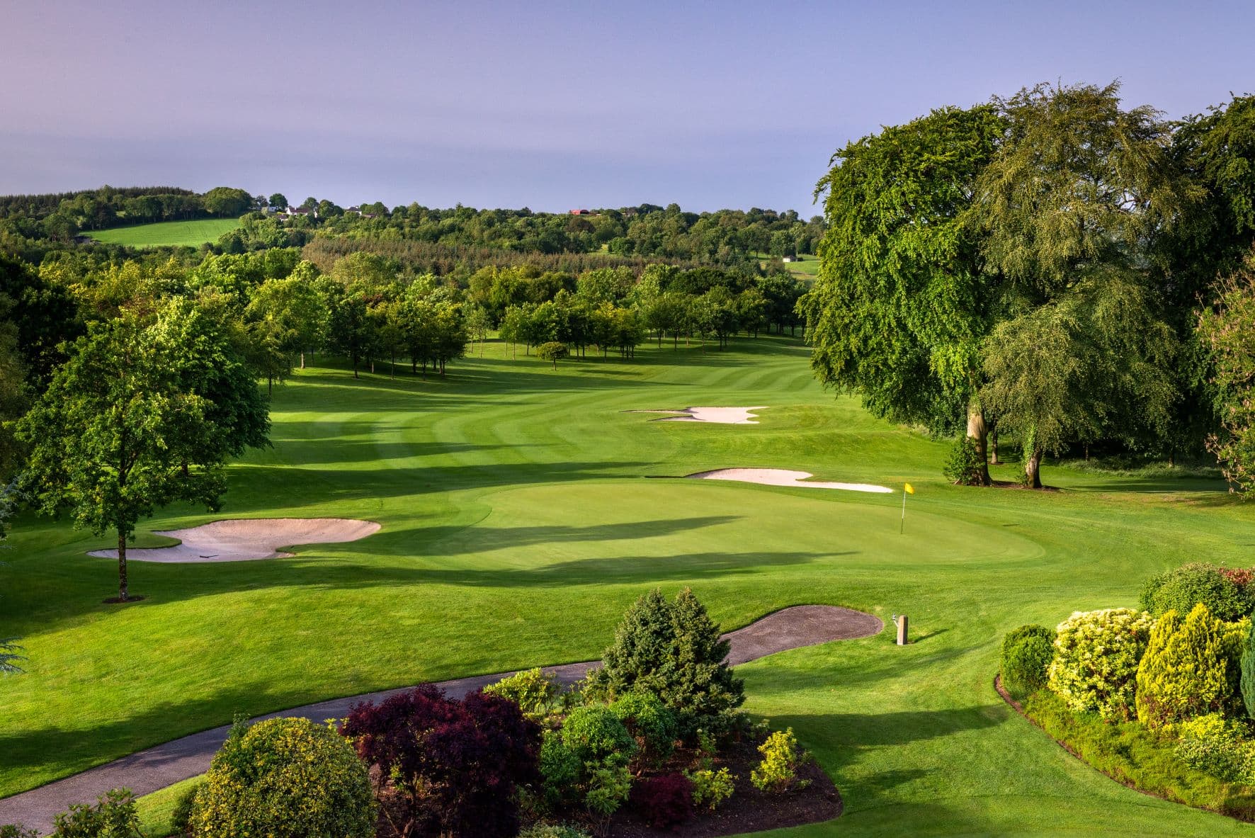 Wide angle shot of the greens at the PGA National course with wide fairways and well-kept grass