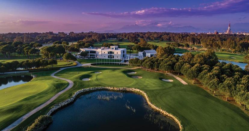 Green with water in front and the clubhouse behind