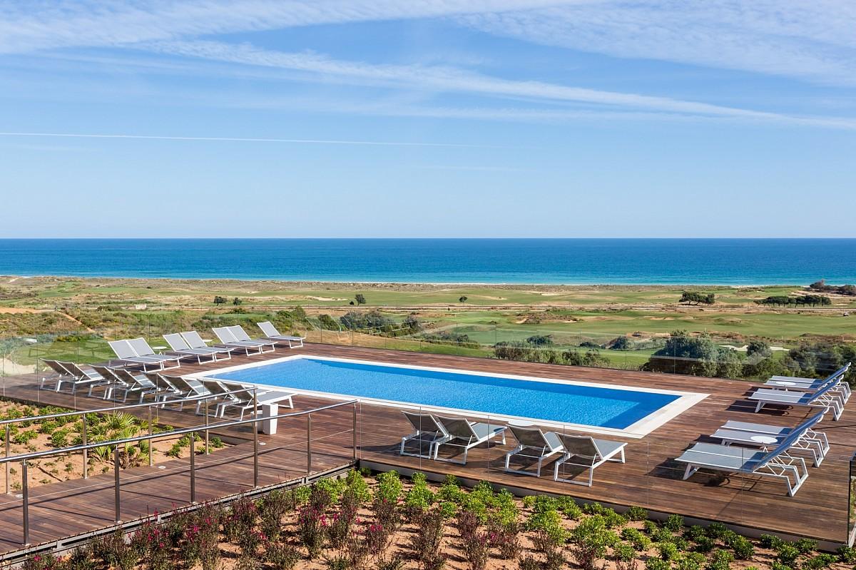 Outdoor swimming pool area with the ocean in the background