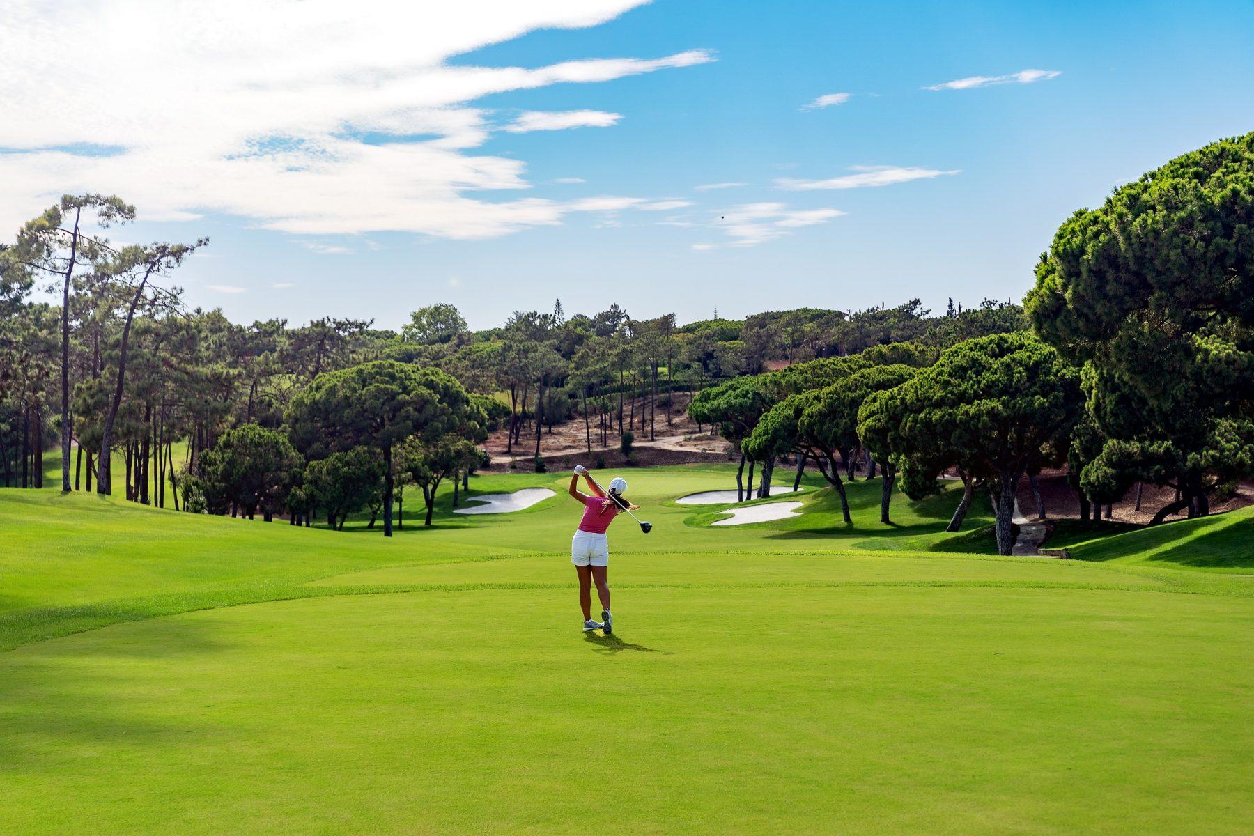 Player taking their approach shot to a downhill green