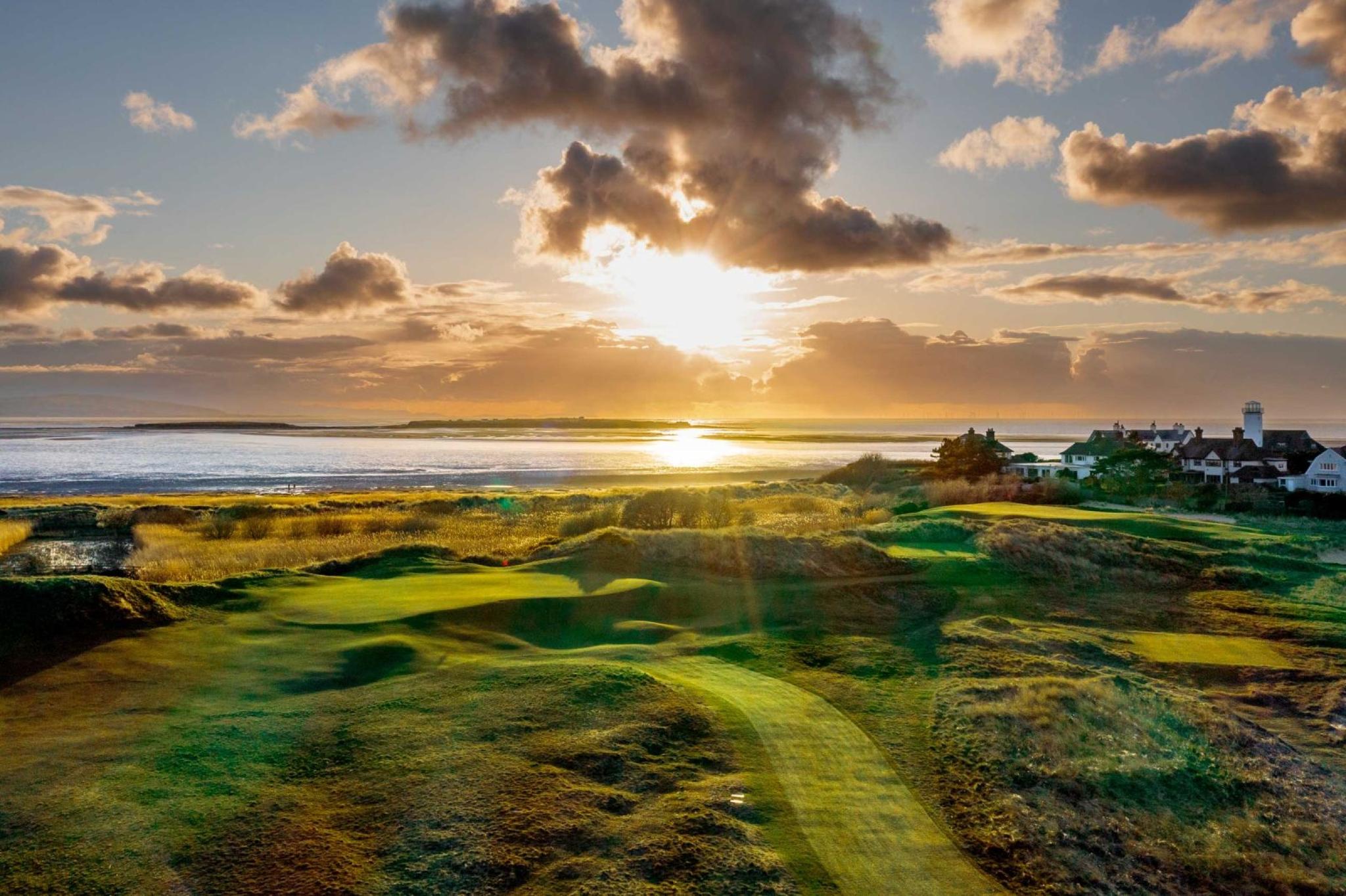 Panoramic view of the golden sun shining down onto the course causing the rolling dunes to shadow