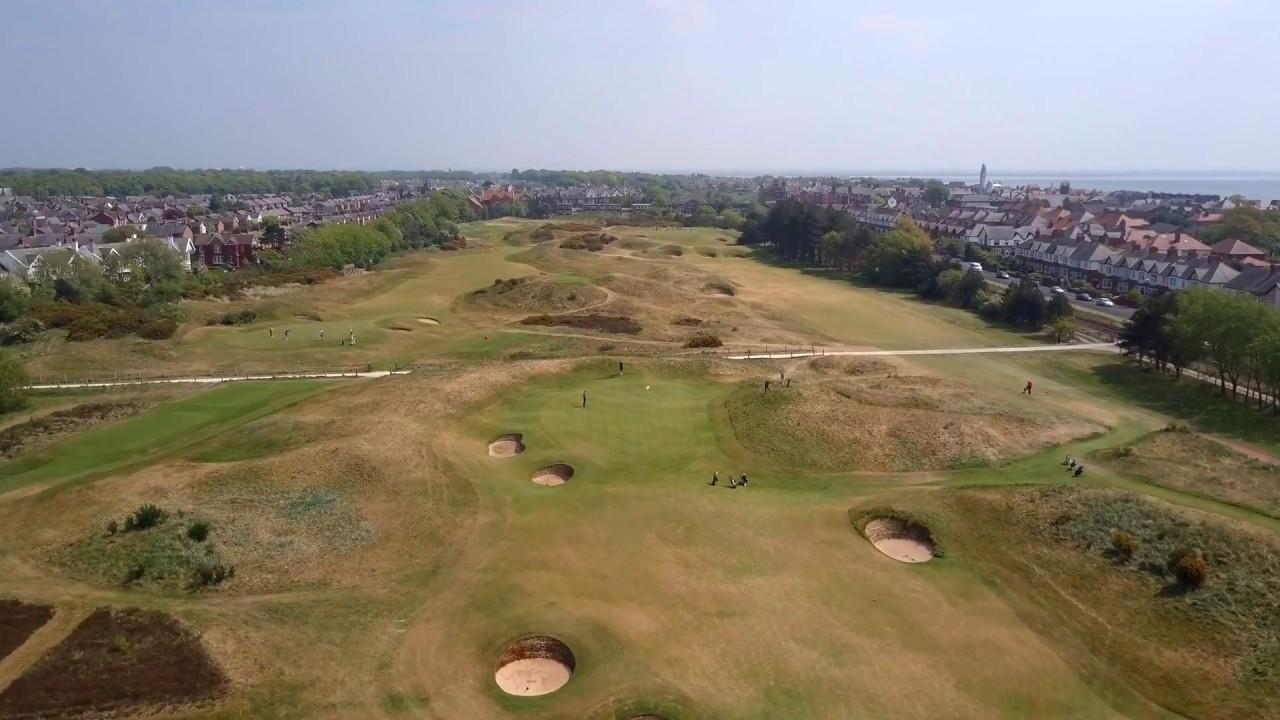 Birdseye view of golfers enjoying their round of golf on firm fairways surrounded by town houses.