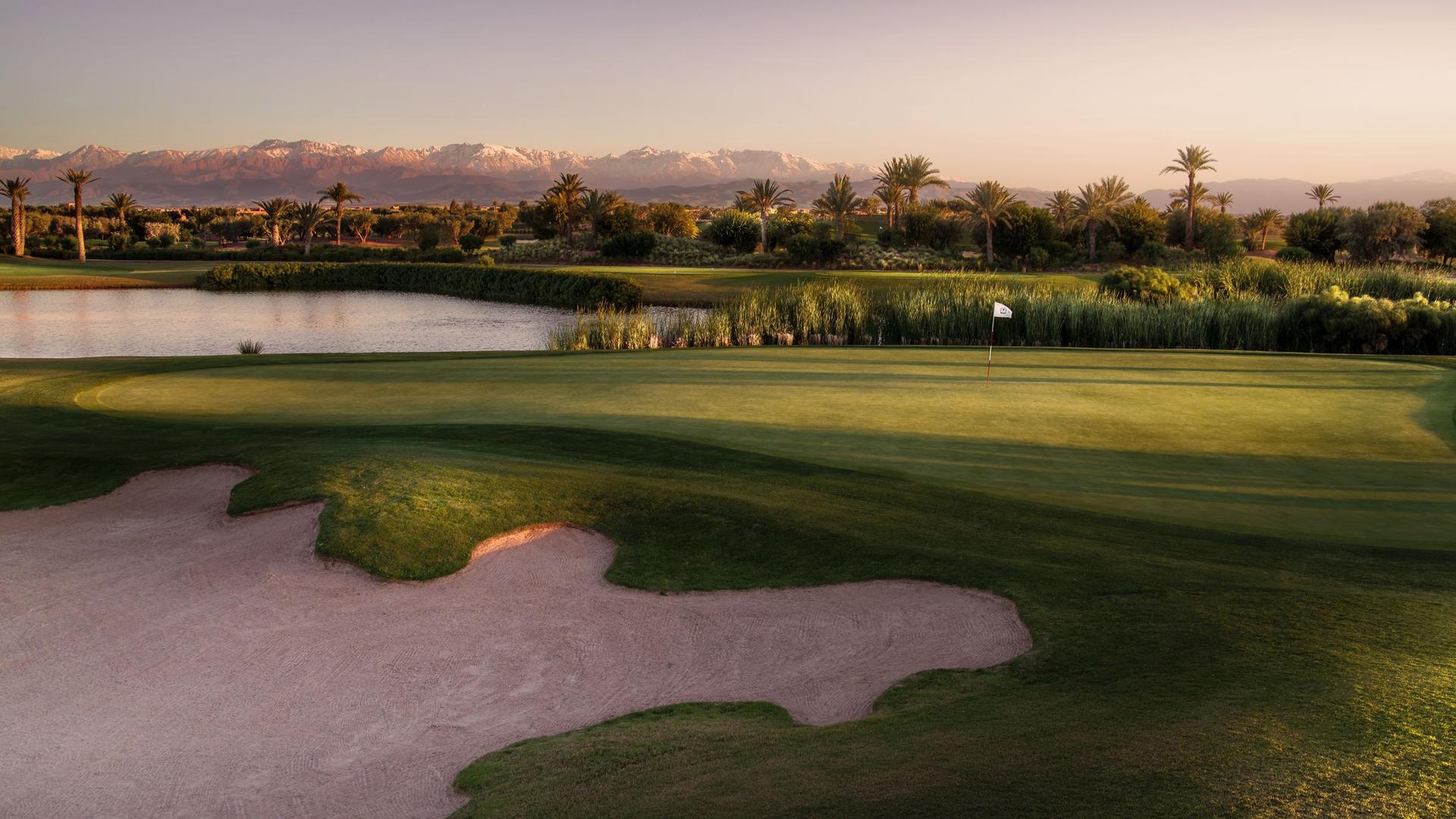A smooth green sandwiched between a water hazard and uniquely shaped sand bunker