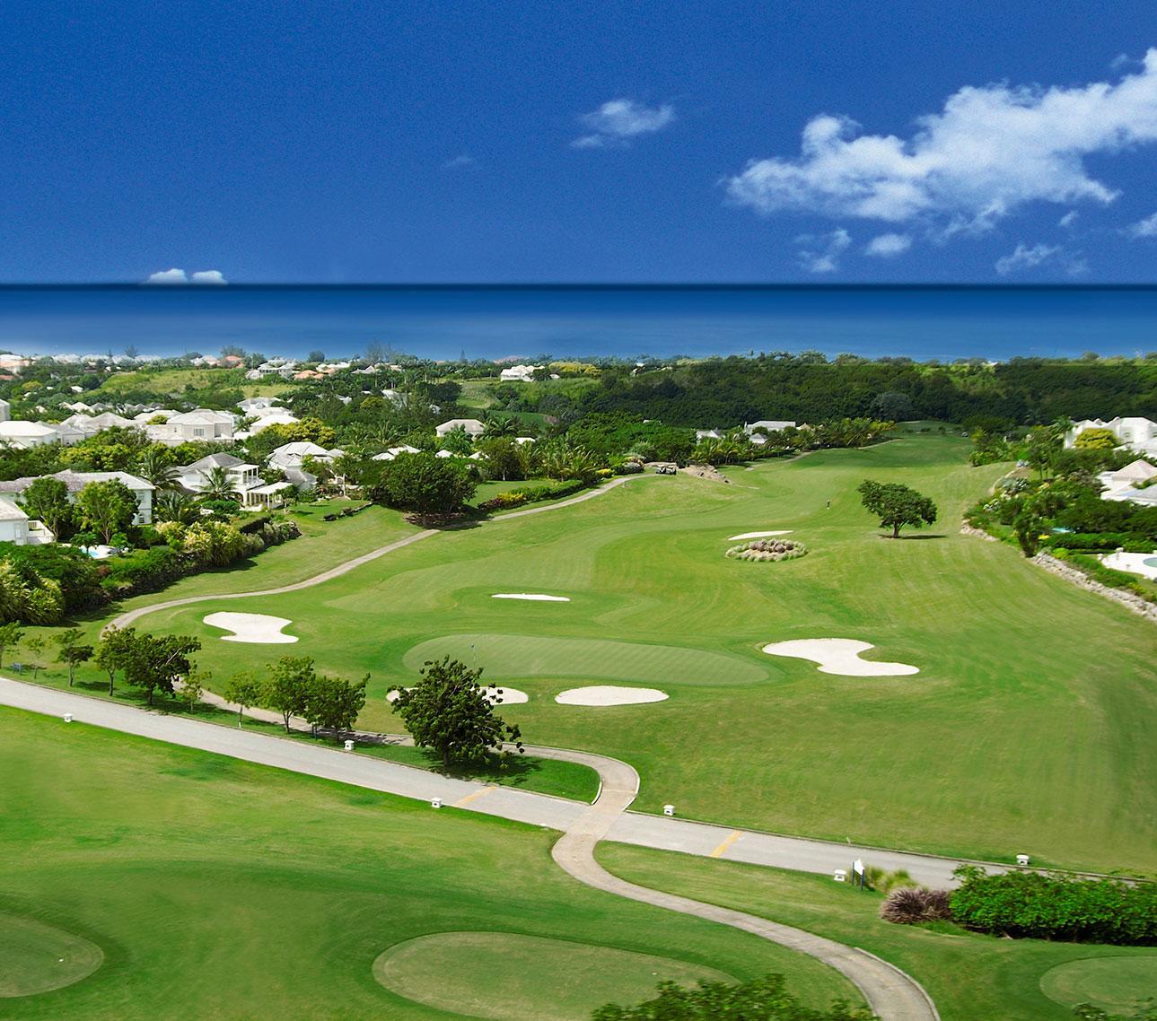 Expansive fairways stretch toward the ocean, bordered by luxury homes.