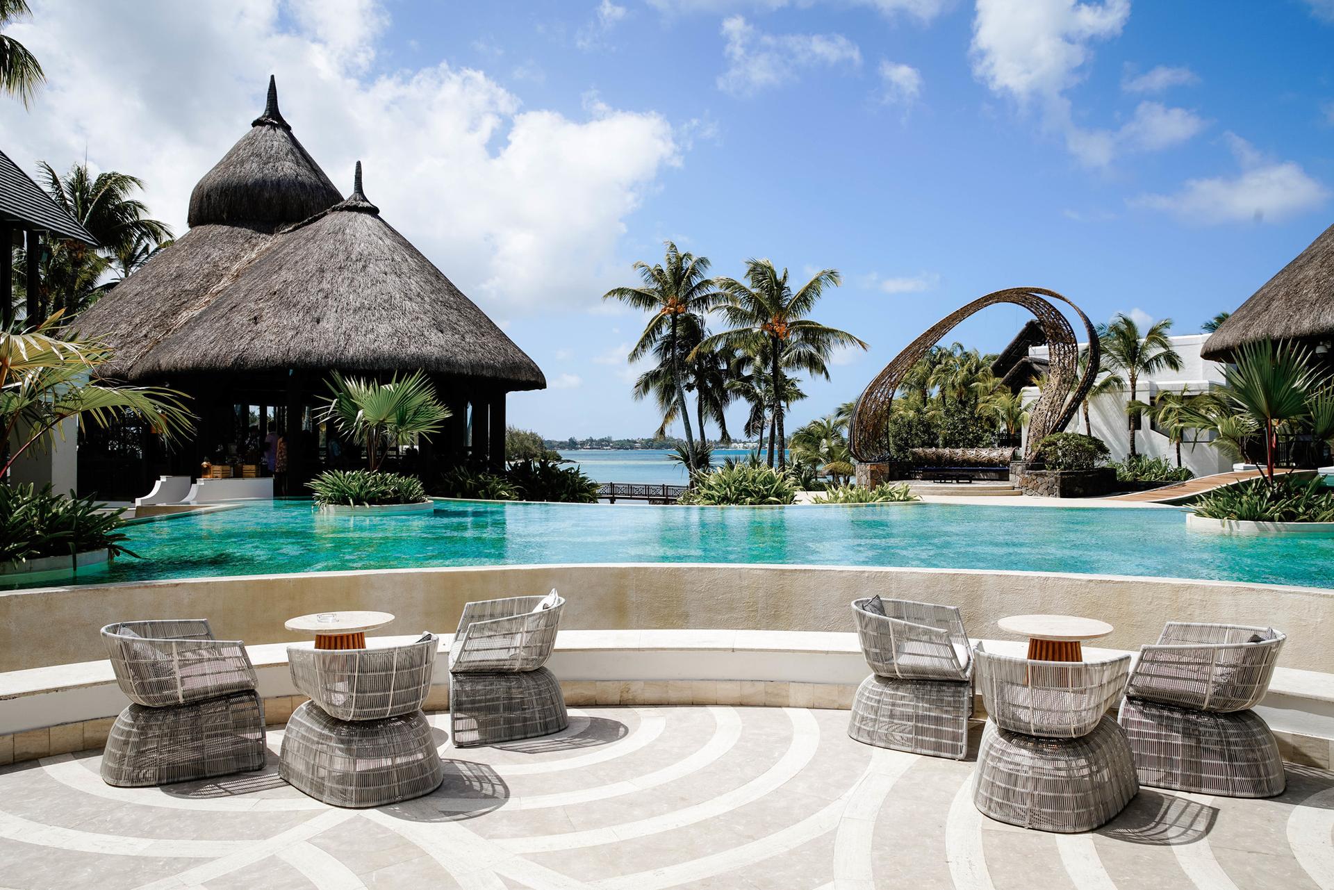 Outdoor swimming pool with poolside seating under blue skies