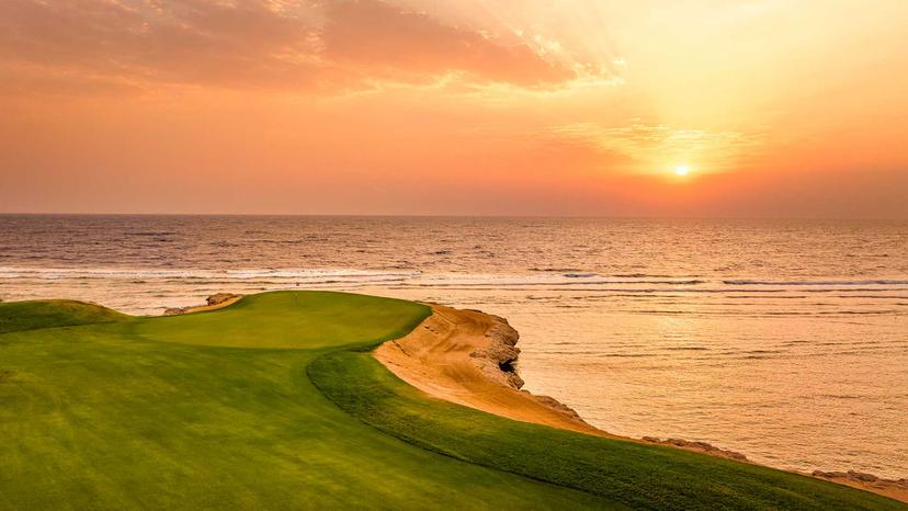 Sun setting over an island like green with coastal views