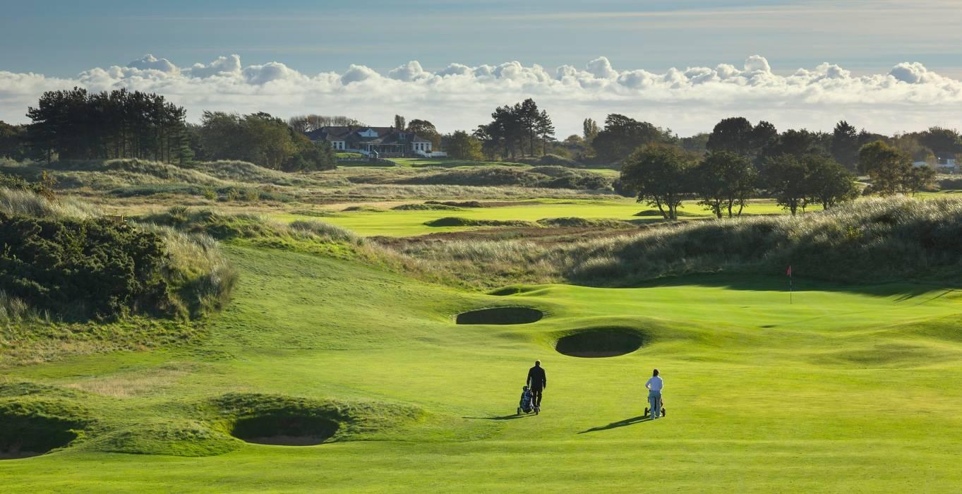 Two Golfers enjoying their round on the course with its mature rough yet manicured greens and fairways