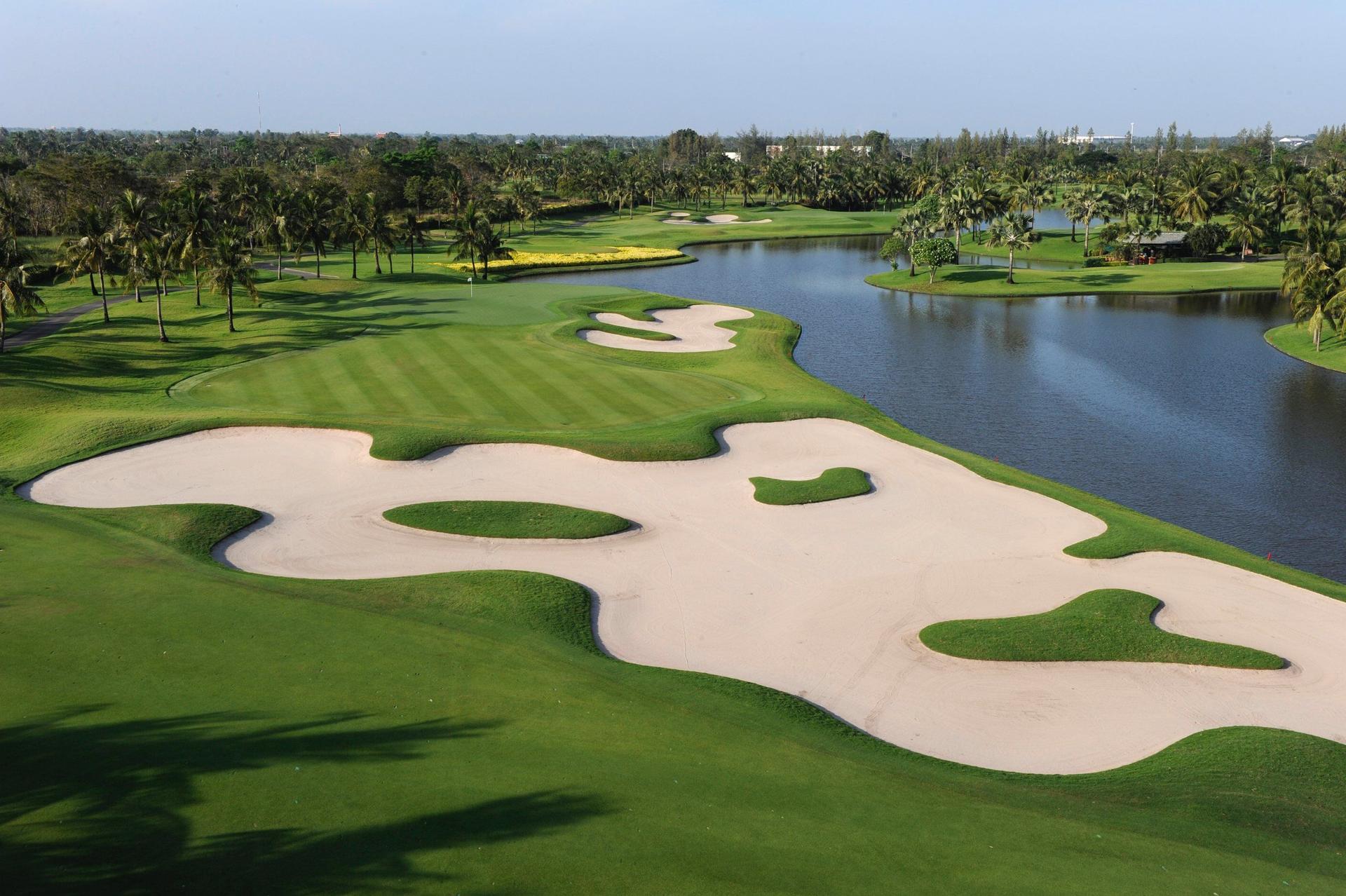 Large bunker with a manicured fairway and water hazard on one side