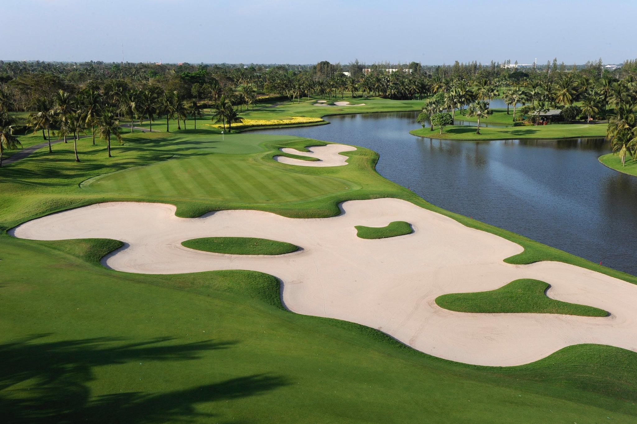 Large bunker with a manicured fairway and water hazard on one side