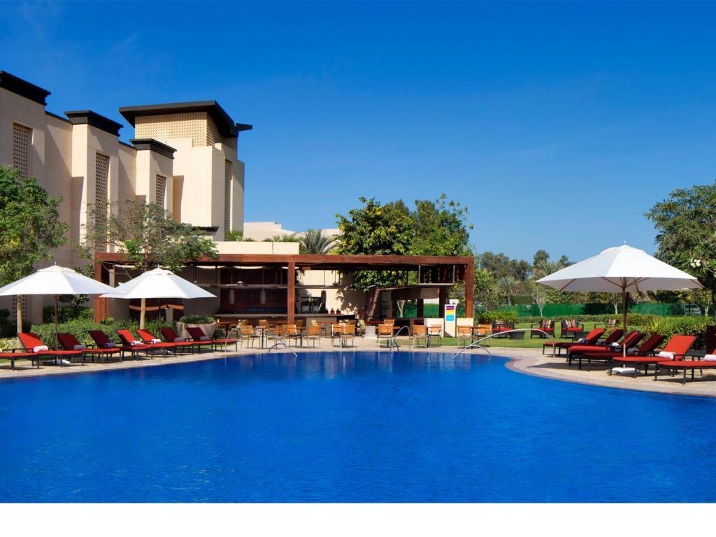An outdoor swimming pool surrounded by sunbeds and umbrellas