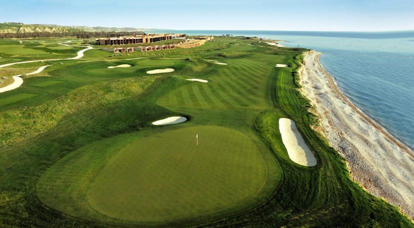 Scenic golf course stretching along the coastline with rolling fairways and sand bunkers.