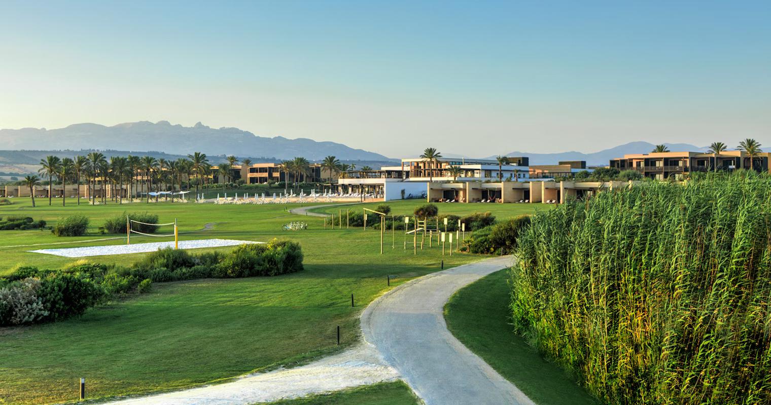Walkway up to the resort building passing a volleyball court and playground