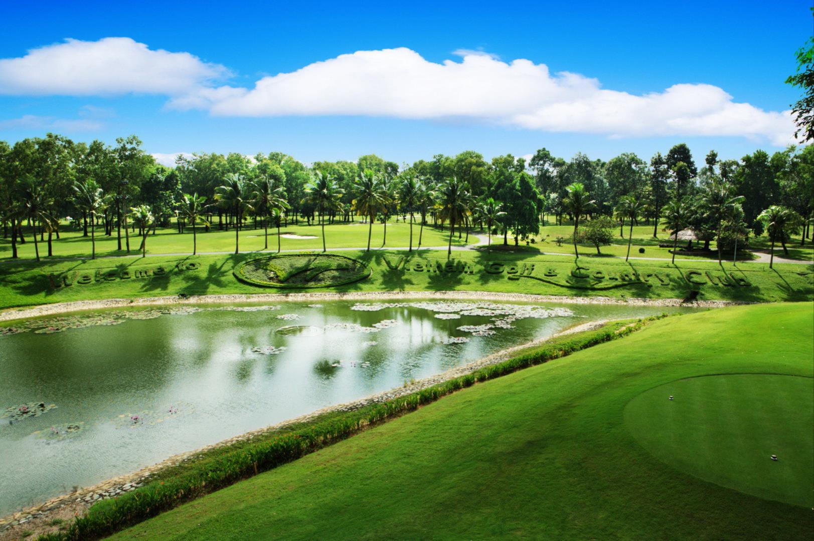 A large water hazard next to the Vietnam Golf & Country Club name sculpted into the rough on the course