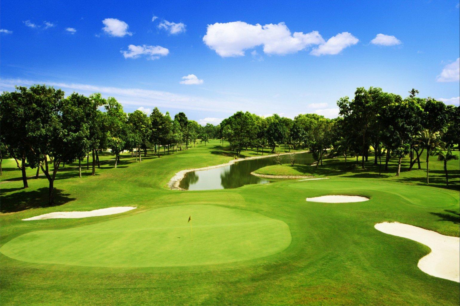 A well maintained fairway leading to a smooth green surrounded by sand bunkers