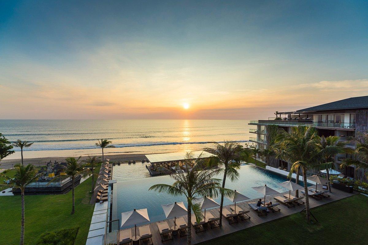 Sun setting over the outdoor swimming pool with coastal views