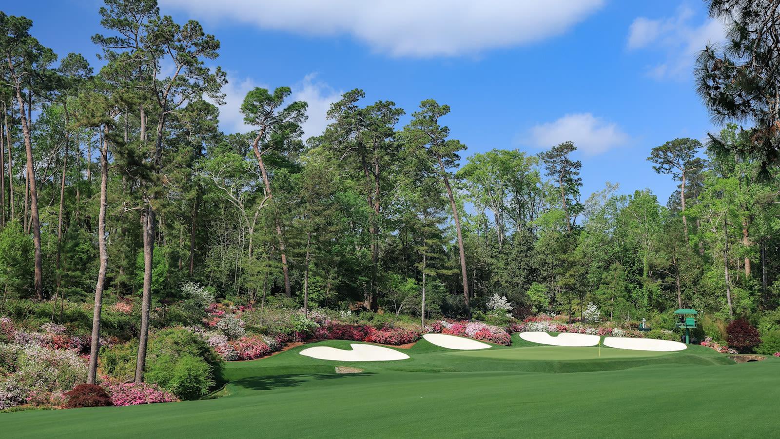 Lush fairway leading to a green over water with bunkers behind it
